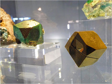 Crystal and model. Cuprite pseudomorphed into malachite from Onganja, Namibia, with its crystallographic wood model. Natur Musée collection. (Photo: Eloïse Gaillou)