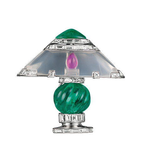 Lamp clip, 1929, by Van Cleef & Arpels. Platinum, ruby, emeralds, moonstone, diamonds, one carved emerald 8.19 carats, one cabochon-cut emerald 1.25 carats. (Photo: © Van Cleef & Arpels)
