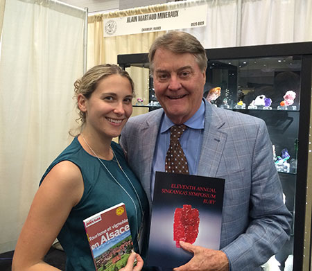 Pala International's Bill Larson poses in Tucson with Eloïse Gaillou, curator of the Natural History Museum of Los Angeles. Eloïse has her Alsace guidebook in preparation for the " European Gem & Mineral Experience: a trip organized by the curatorial staff of NHMLAC ," June 27th – July 7th, 2014, with stops in Idar-Oberstein, Sainte-Marie-aux-Mines, mines & vines & wines, and more. (Note: This tour has been cancelled.) Bill holds the revised edition of the proceedings of the Eleventh Annual Sinkankas Symposium – Ruby. This lovely, 130-page volume, co-published by Pala International, will be available for online purchase soon; check the Symposium website for news. The cover star of the proceedings is the Hixon ruby, which happens to be owned by Eloïse's institution. It's a pristine natural crystal, from the Mogok Stone Tract; at 196 carats, it is one of the finest Burmese rubies on display in a public museum. The ruby was photographed by Harold and Erica Van Pelt. (Photo: Will Larson)