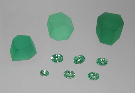 Rough and cut V-bearing synthetic chrysoberyl grown by Kyocera Corporation. The top-right piece weighs 10.5 g and measures 15.5 × 15.5 × 14.4 mm; the faceted samples weigh 0.49–1.33 ct. (Photo: Karl Schmetzer)