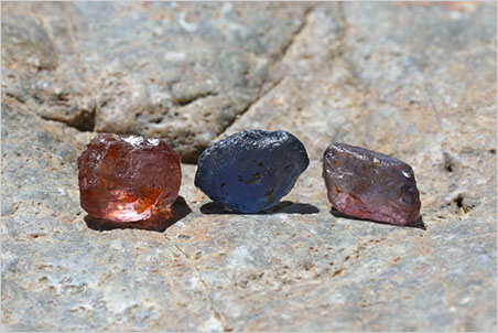 Rough sapphire…? The unidentified dumortierite on the left before cutting, alongside actual sapphires.