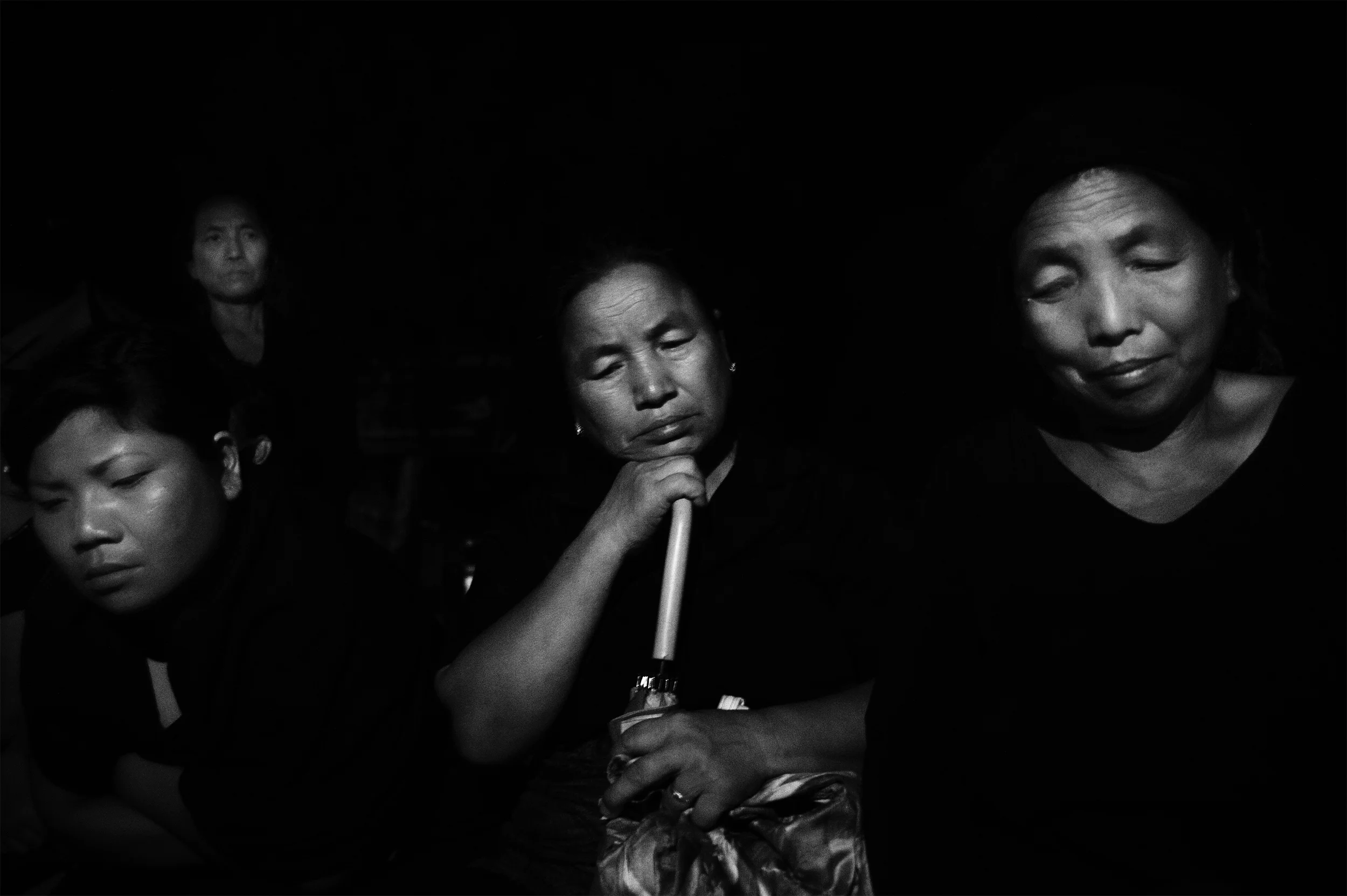 September, 2015: Women enforce night curfew as the protest gathers momentum in Churachandpur, Manipur, India. Dressed in black, women of the town took to the streets of Churachandpur, at the intersection of every village, every town square and road. Armed with sticks, they occupied long wooden benches and took turns to chant slogans against the government. 