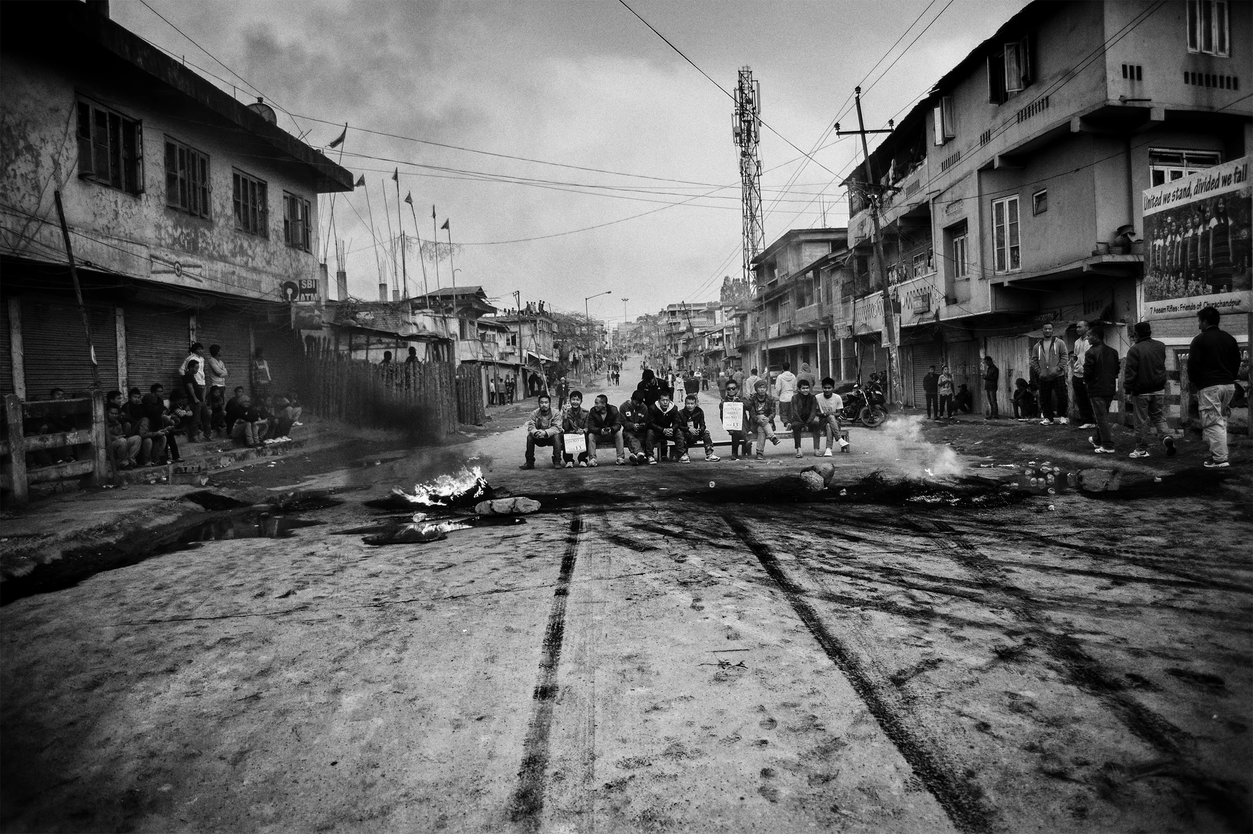February, 2016: Soot covers the street as tyres burned non-stop at Sielmat, a small village in Lamka, Churachandpur, Manipur, India, as hundreds of young men and women took turns to block a bridge to prevent the entry of uniformed men into the town.