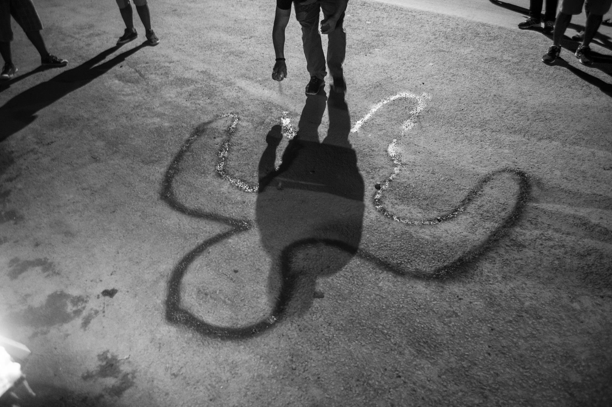 August 2016: A can of red spray paint can be powerful weapon in Churachandpur. On the evening of August 29, young volunteers dressed in black, their faces covered by black cloth, some just in their teens went about town in open pickup trucks, stopping at locations to spray paint, red fallen figures of the dead onto the street mobilising the the locals in the process, who gathered and prayed around and lit candles on and around the figures.