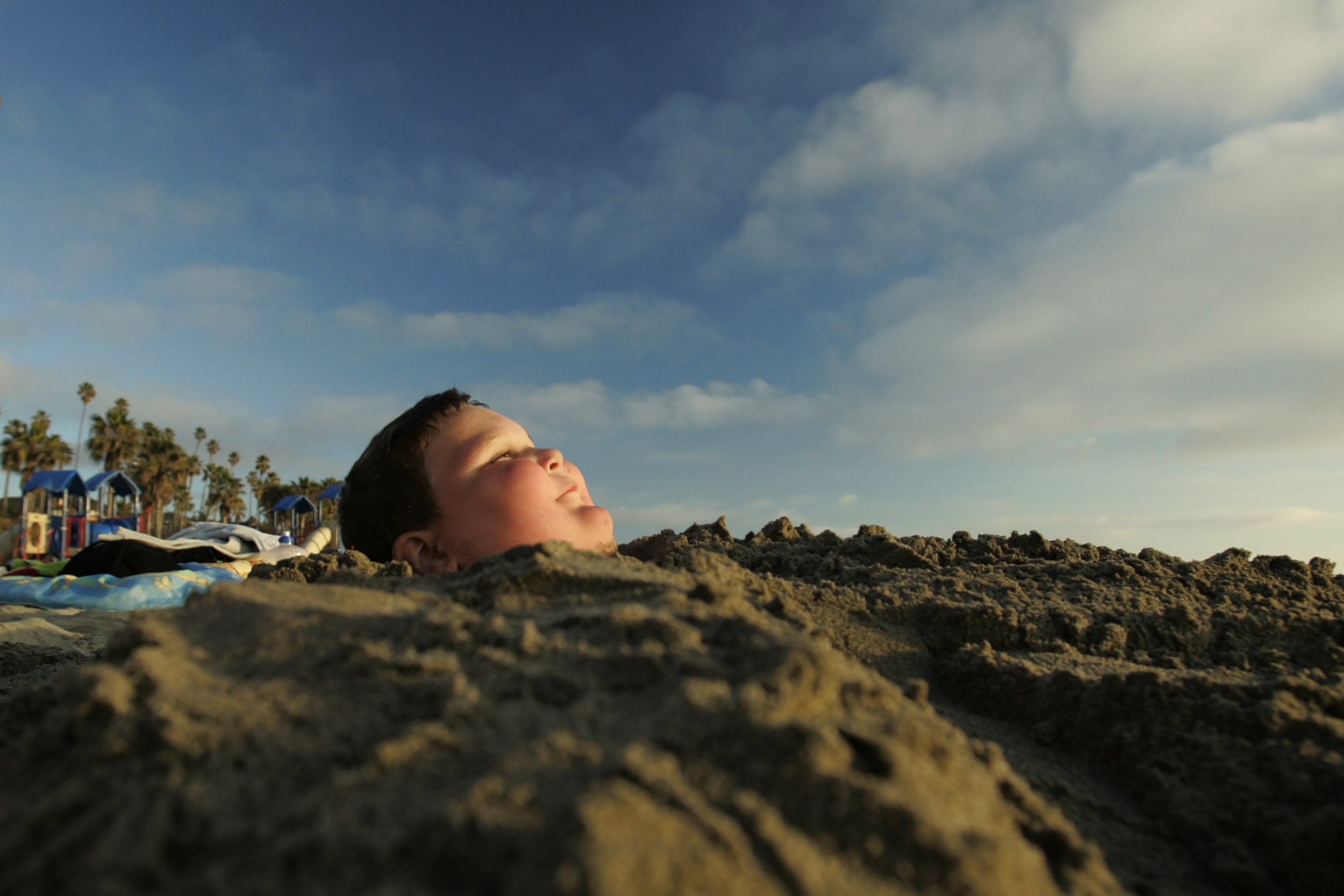 Drew Jordan, 5, of Granite City, Illinois, got buried by his beach buddies during a sunny Winter day down on the south side of the Oceanside Pier in Oceanside, CA.  / 2005