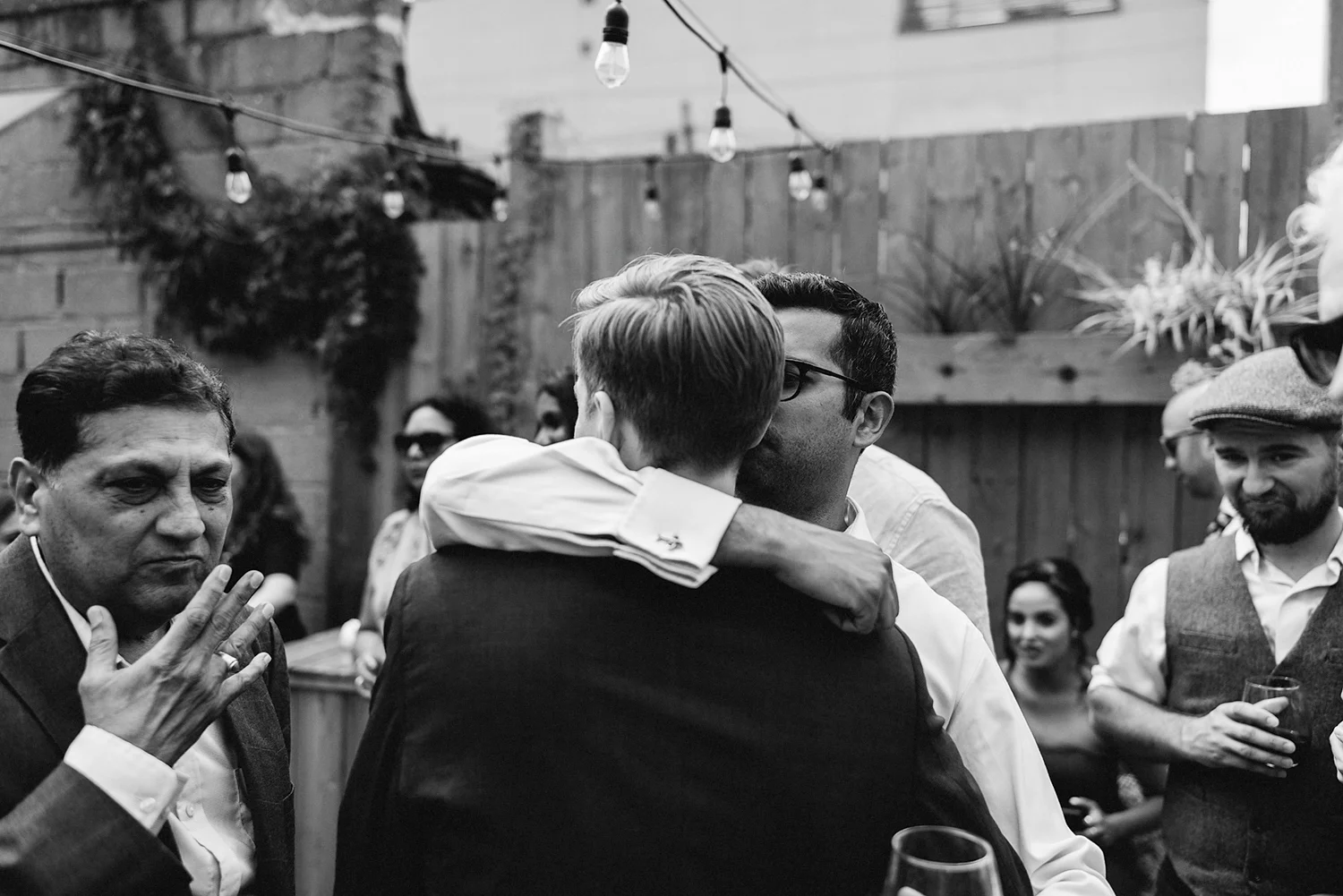film-analog-photography-toronto-film-wedding-photographers-alternative-reception-bar-pray-tell-cocktail-hour-reception-on-the-patio-casual-bride-and-groom-hugging-guests-smiling-happy-celebrating-family-brother.jpg