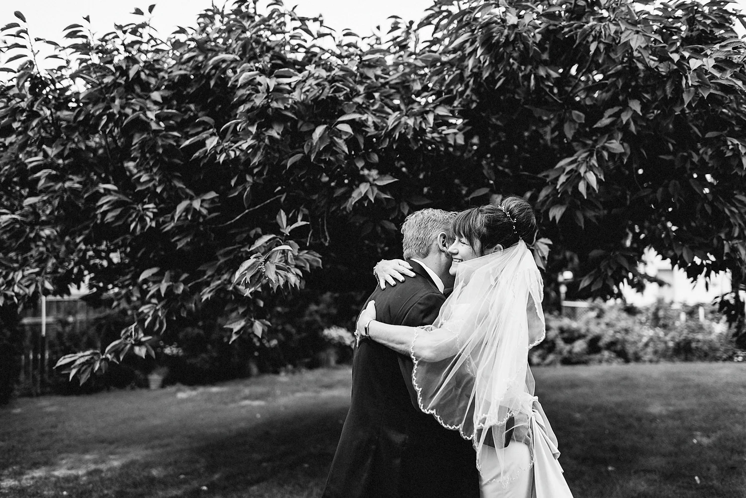 Best-Moody-Documentary-Wedding-Photographers-in-Toronto-Canada-Vintage-Photojournalistic-Wedding-photography-Epic-Moody-Cinematic-First-Look-in-Brides-Parents-backyard-kissing-BW.jpg