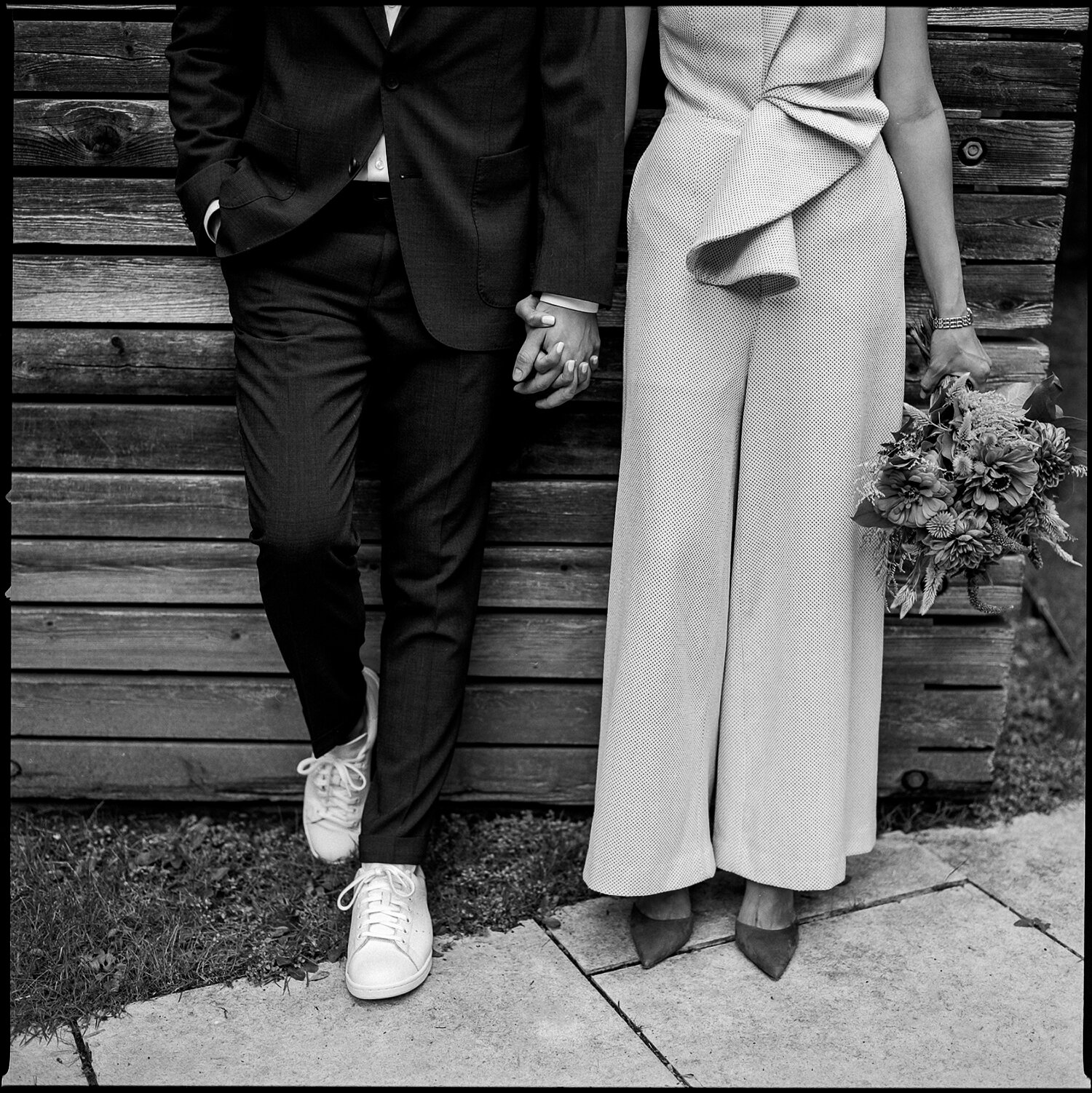 Bride-and-Groom-wearing-Sneakers-and-blue-heels-for-wedding-analog-wedding-photographers-toronto-ontario-canada-vintage-vibes-trendy-modern-downtown-toronto-restaurant-wedding-candid-portrait-quiet-moment-black-and-white-film-photography.JPG