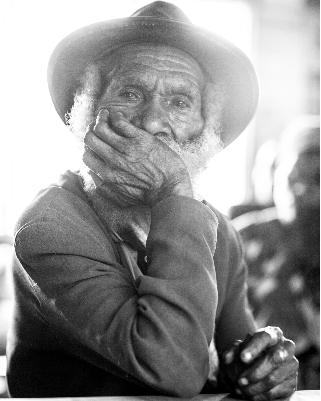 A tribal elder in rural Enga Provence, Papua New Guinea. Sitting for hours listening to external monitors discussing the future of his children education. 