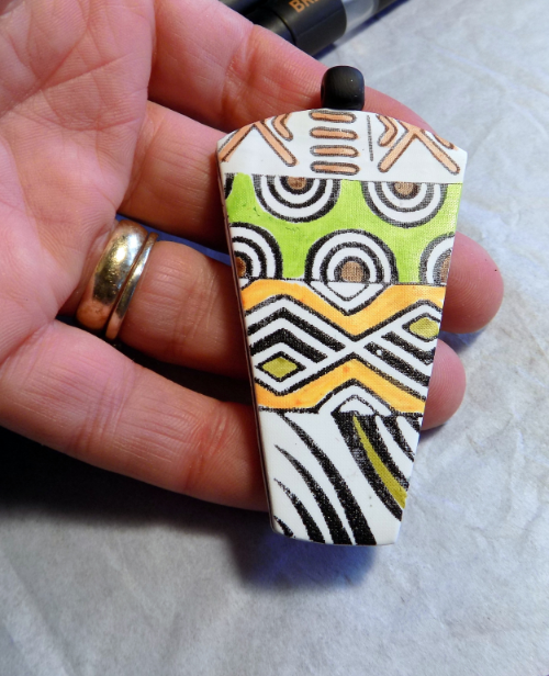 A cool black and white tribal pendant with pops of color from Chameleon pens!