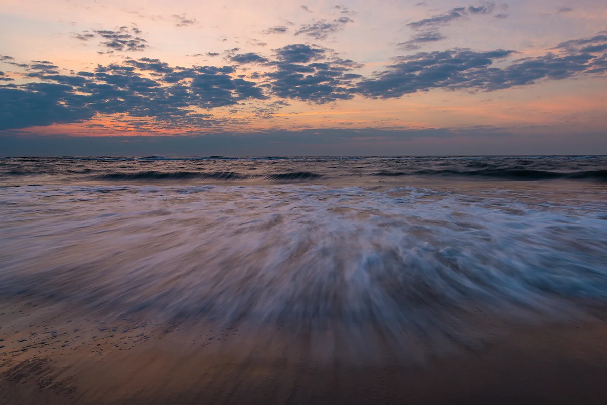 A typical seascape a sunrise captured with an ultra wide-angle lens. I waited until a wave broke just before tripping the shutter to capture a dramatic foreground complimented by the sunrise sky.