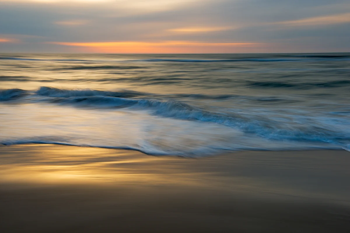 Just a few minutes later....I used a medium telephoto lens to capture an artistic rendition of sunrise over the Ocean. I panned the camera in a horizontal motion during a 1 second exposure.