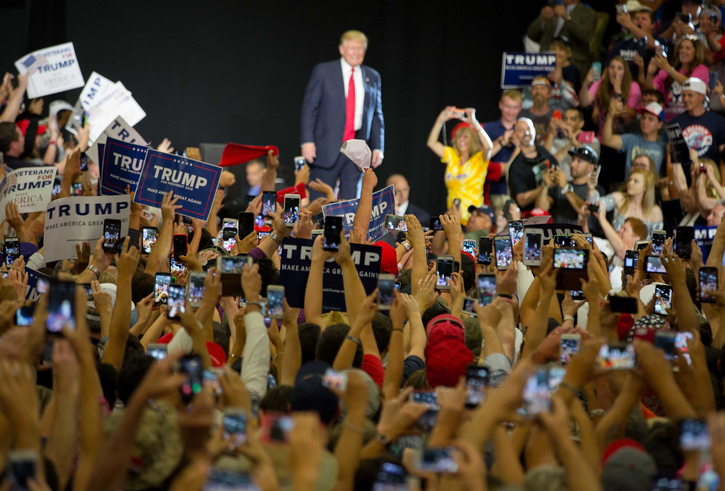  People inside the Albuquerque Convention Center takes photos of presidential candidate Donald Trump as he walks towards a podium, May 24, 2016. 