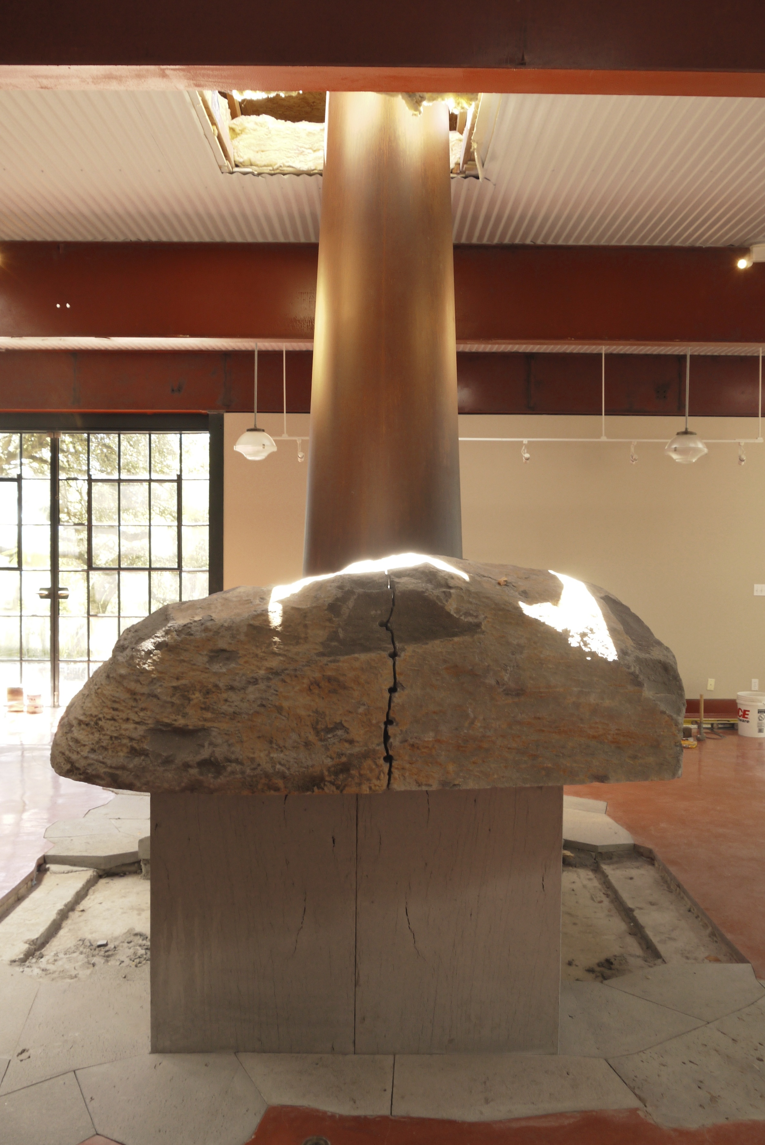  Metal and stone fireplace, process.&nbsp;Bookend stone with cone installed before the hole patching. 