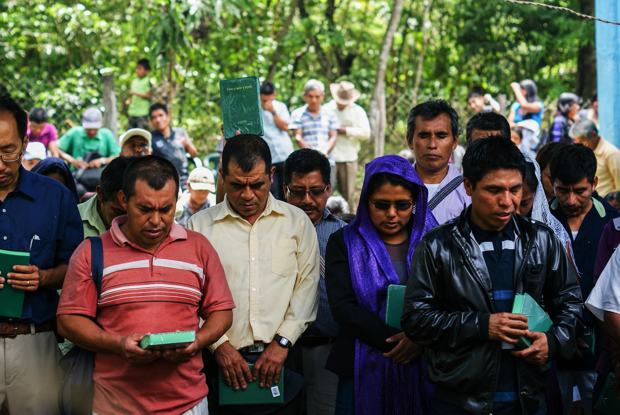 Leaders praying over the new Bibles.
