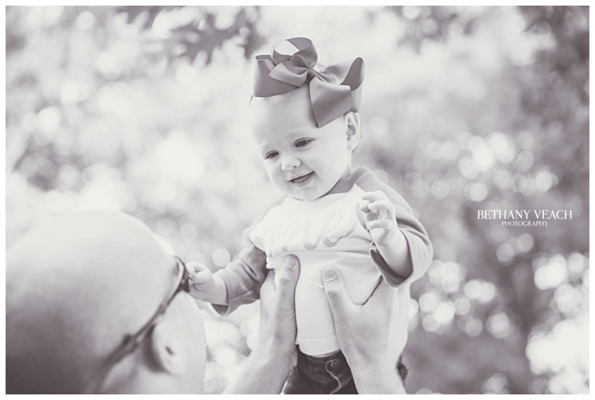 daddy holds baby in air