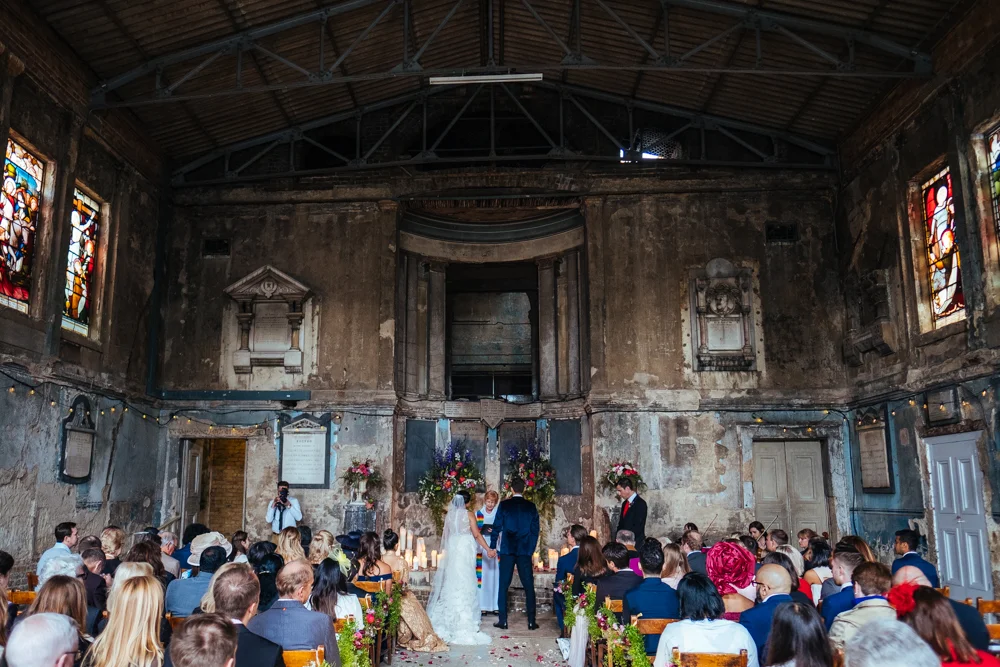wedding ceremony inside Asylum Chapel Peckham with guests seated and couple at altar