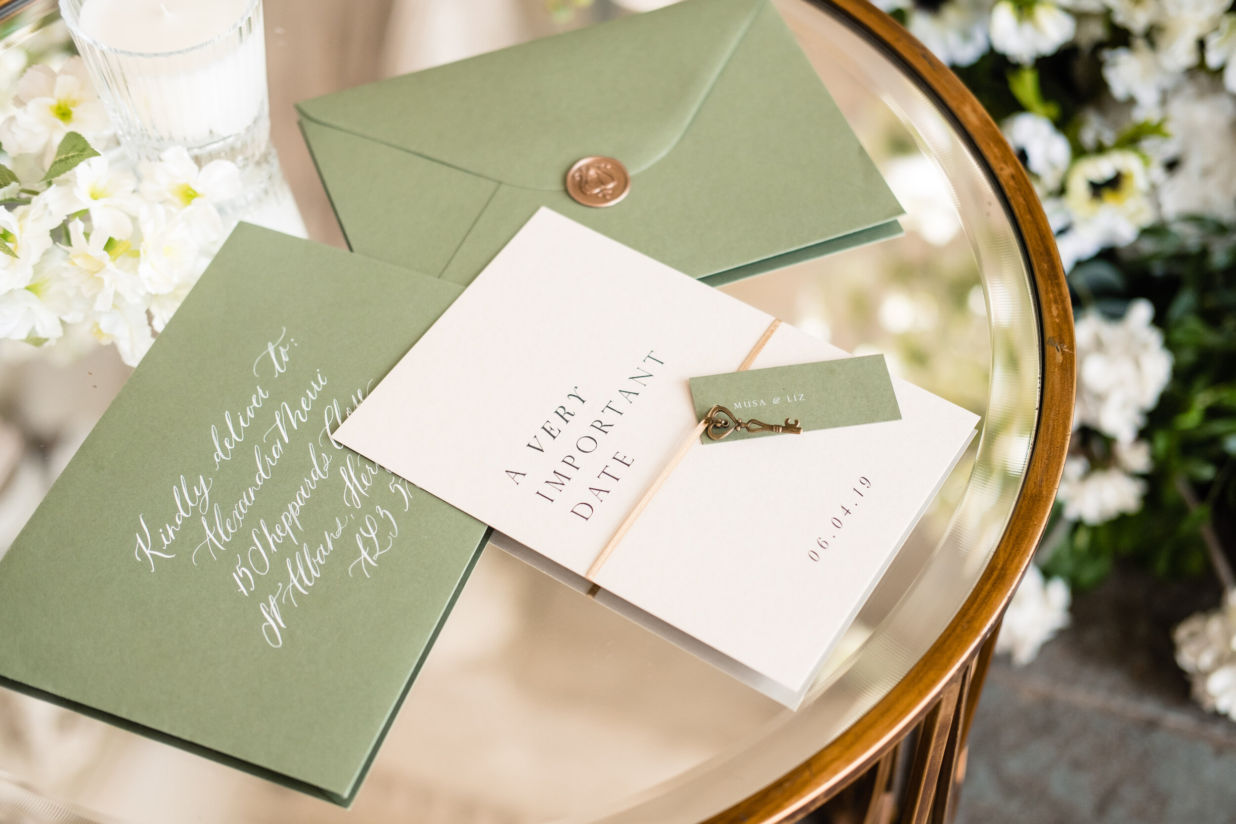 green wedding stationery on mirrored table