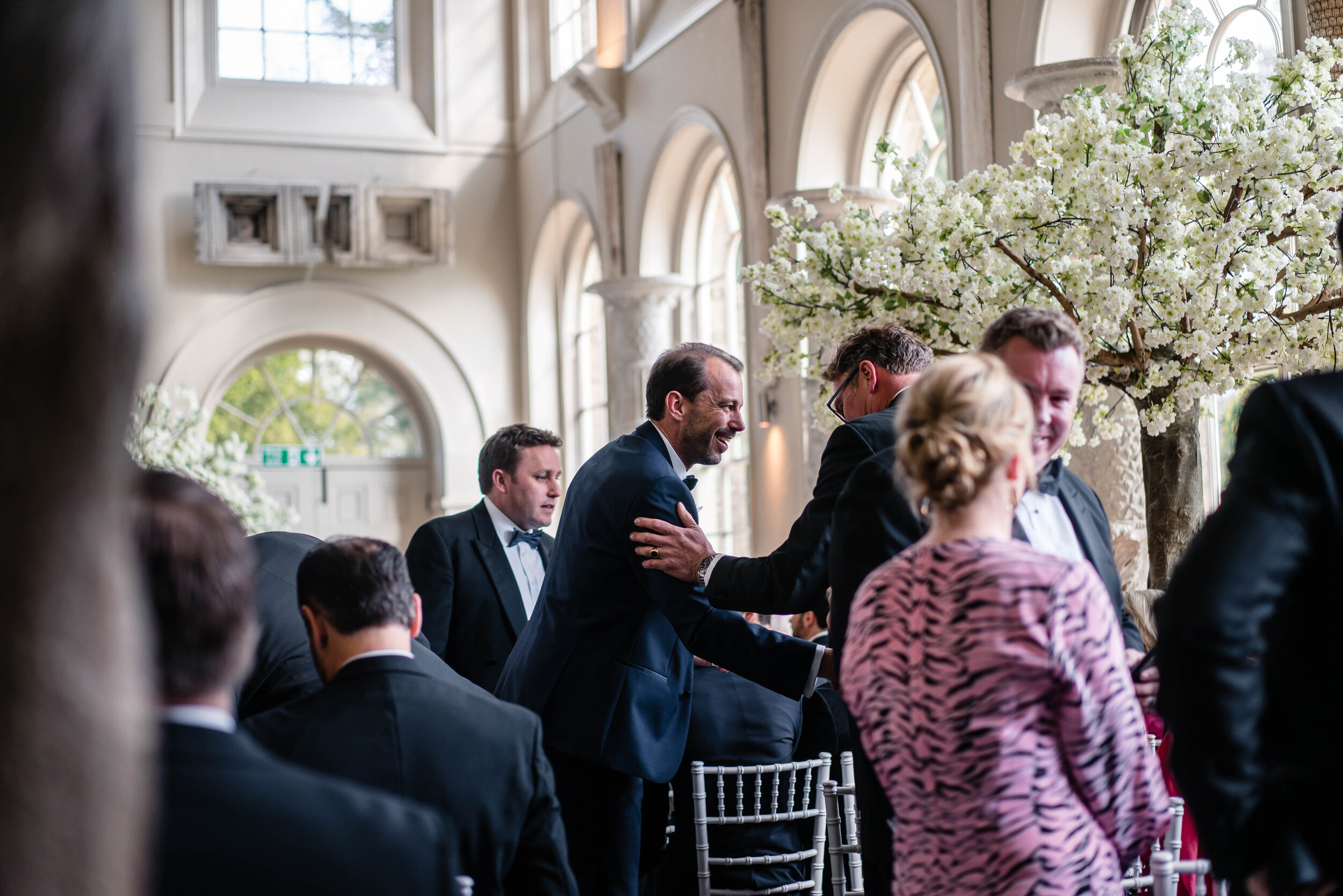 groom greeting guests in wedding venue