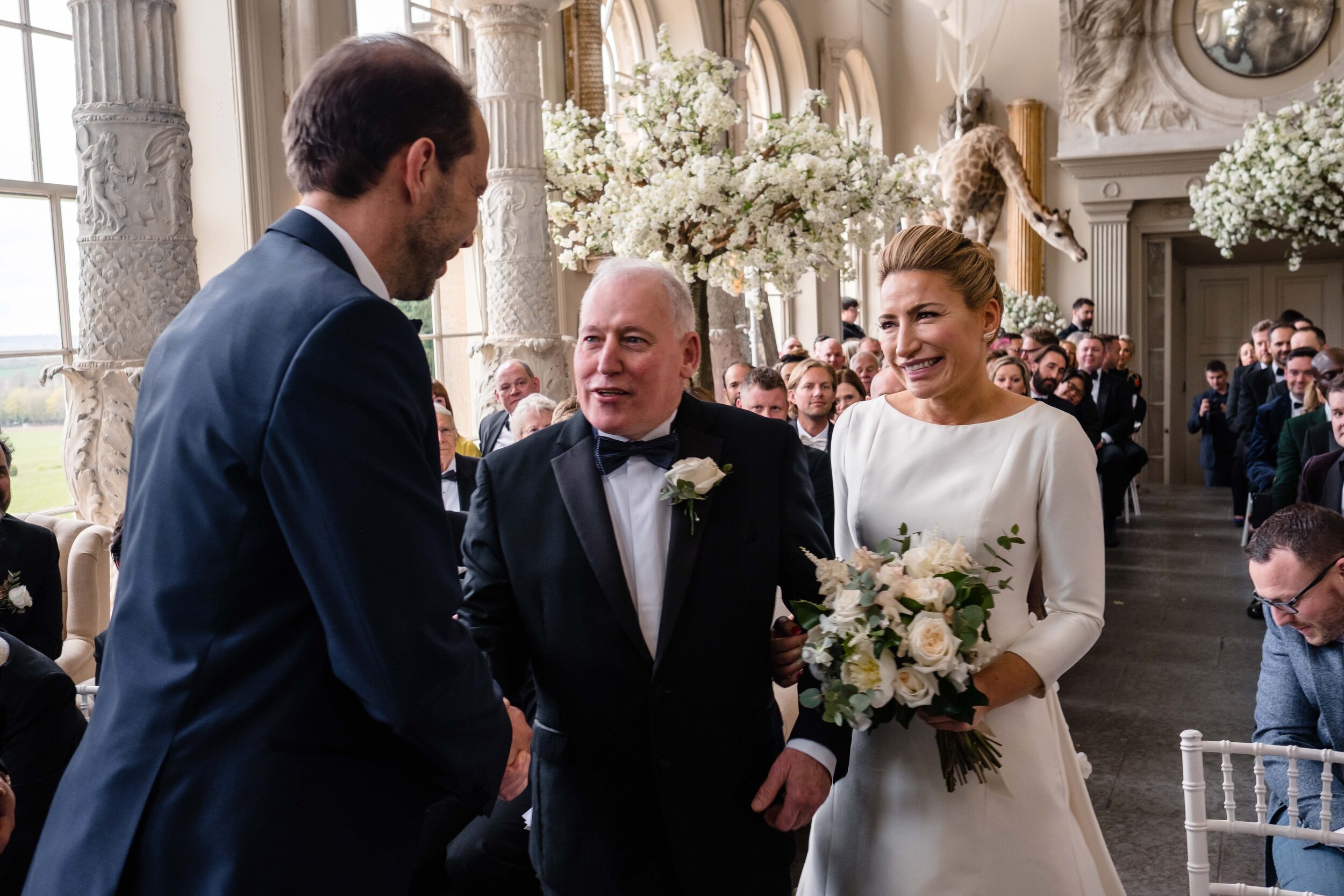 brides father waling her up the aisle to meet the groom smiling