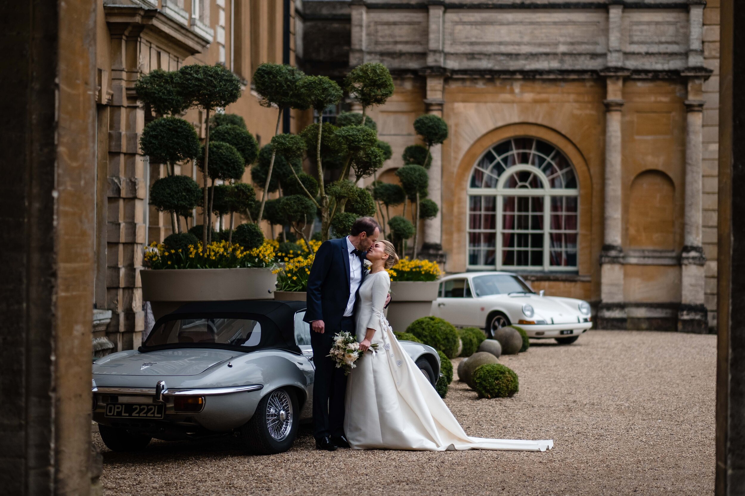 Aynhoe Park wedding photography with bride and groom standing by grey sportscar