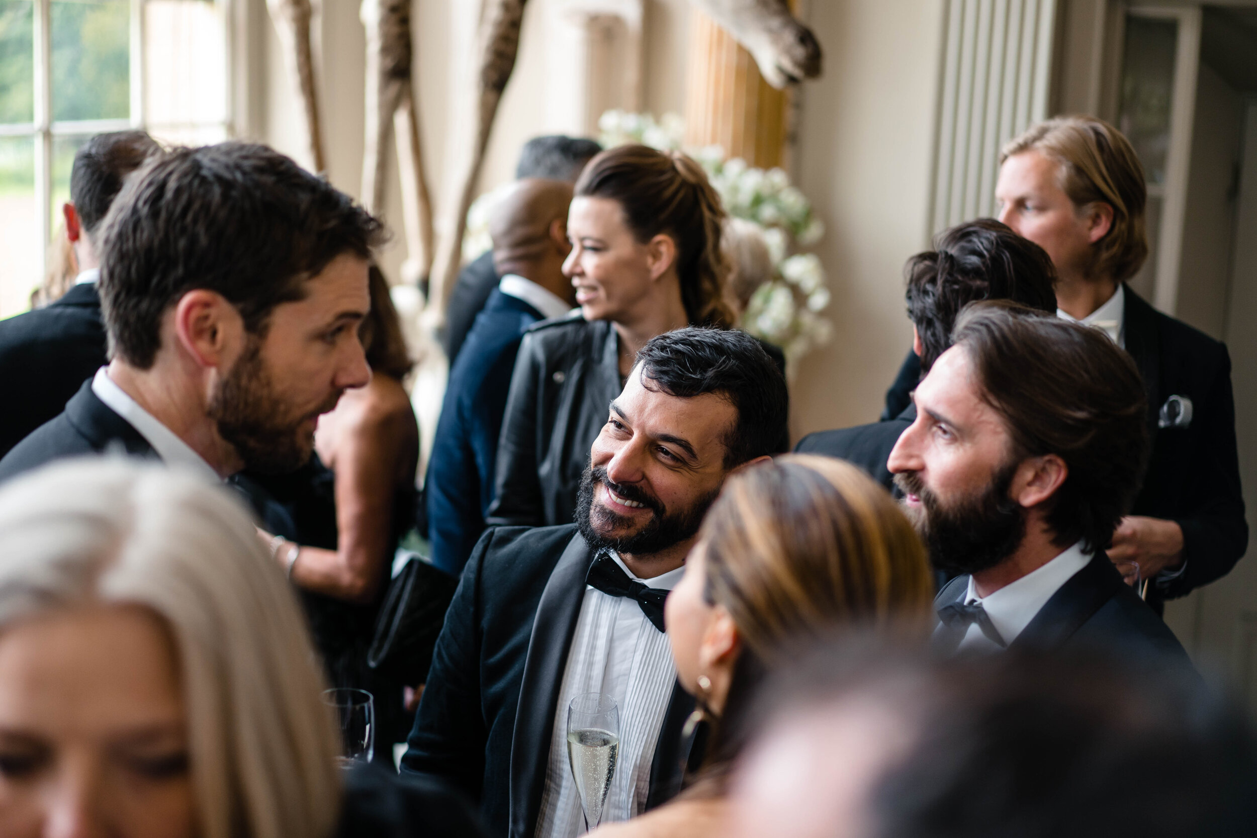 crowd of wedding guests talking and laughing