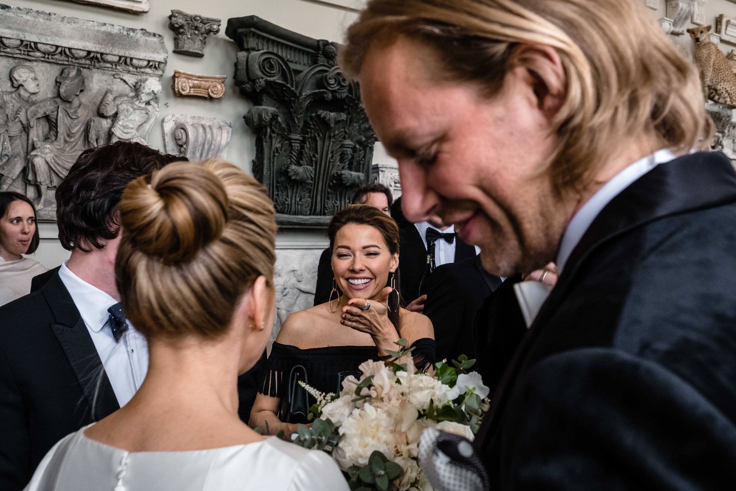 bridesmaid looking and smiling at bride from over brides shoulder