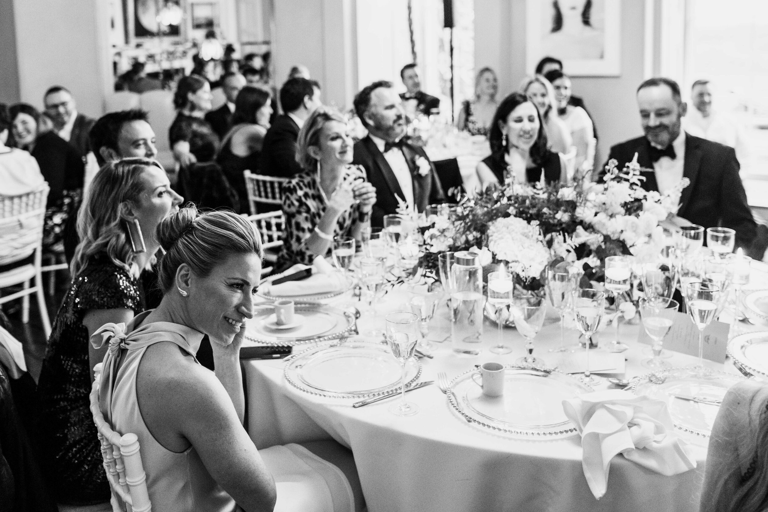 black and white table shot from low angle of bride watching the speaker