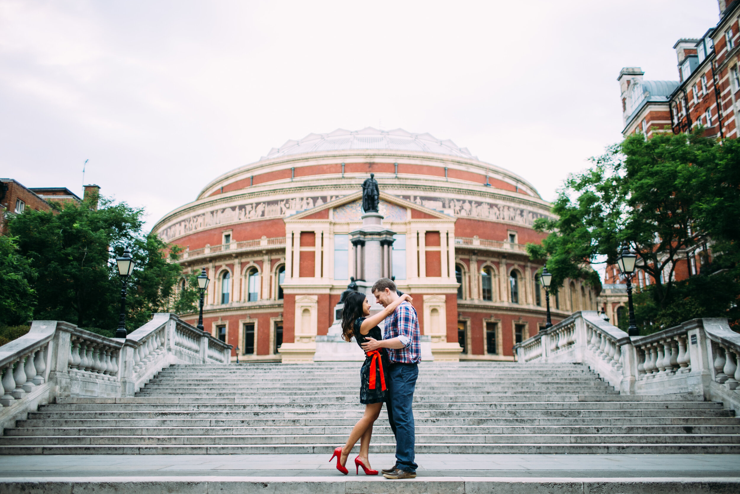 couple embracing on steps in front of the royal opera house in London