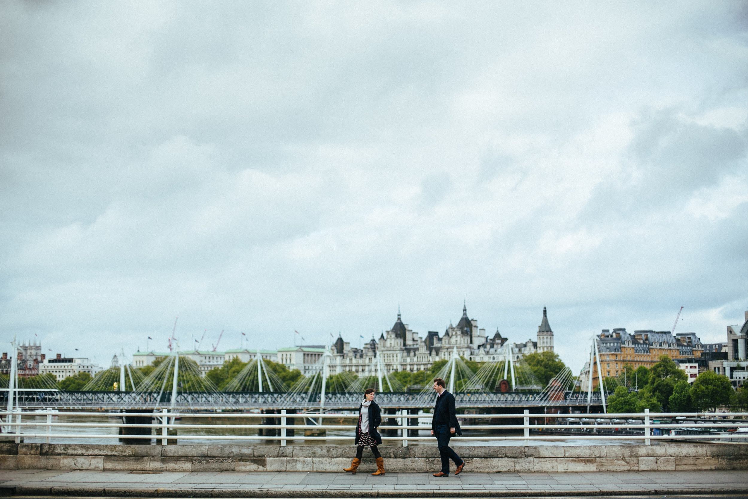 couple walking across London Bridge in London