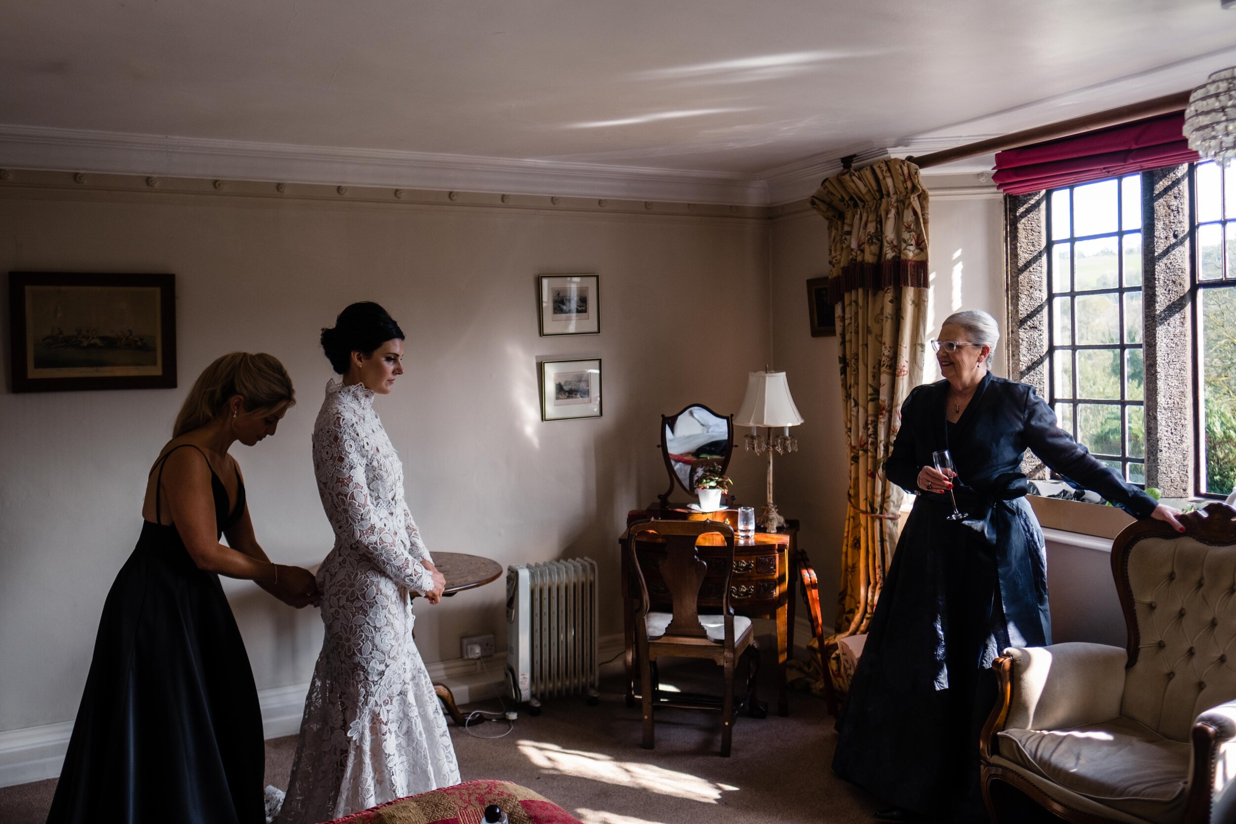 wide shot of bride getting ready in sunlit room