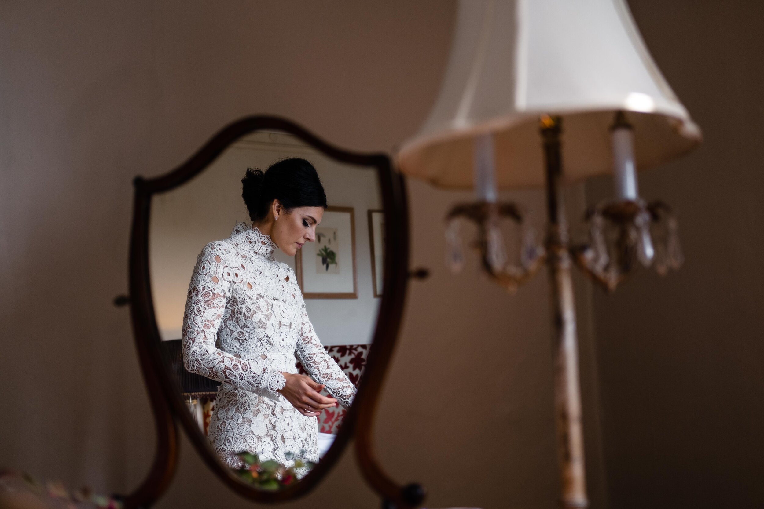 photo of bride in mirror with lampshade in foreground