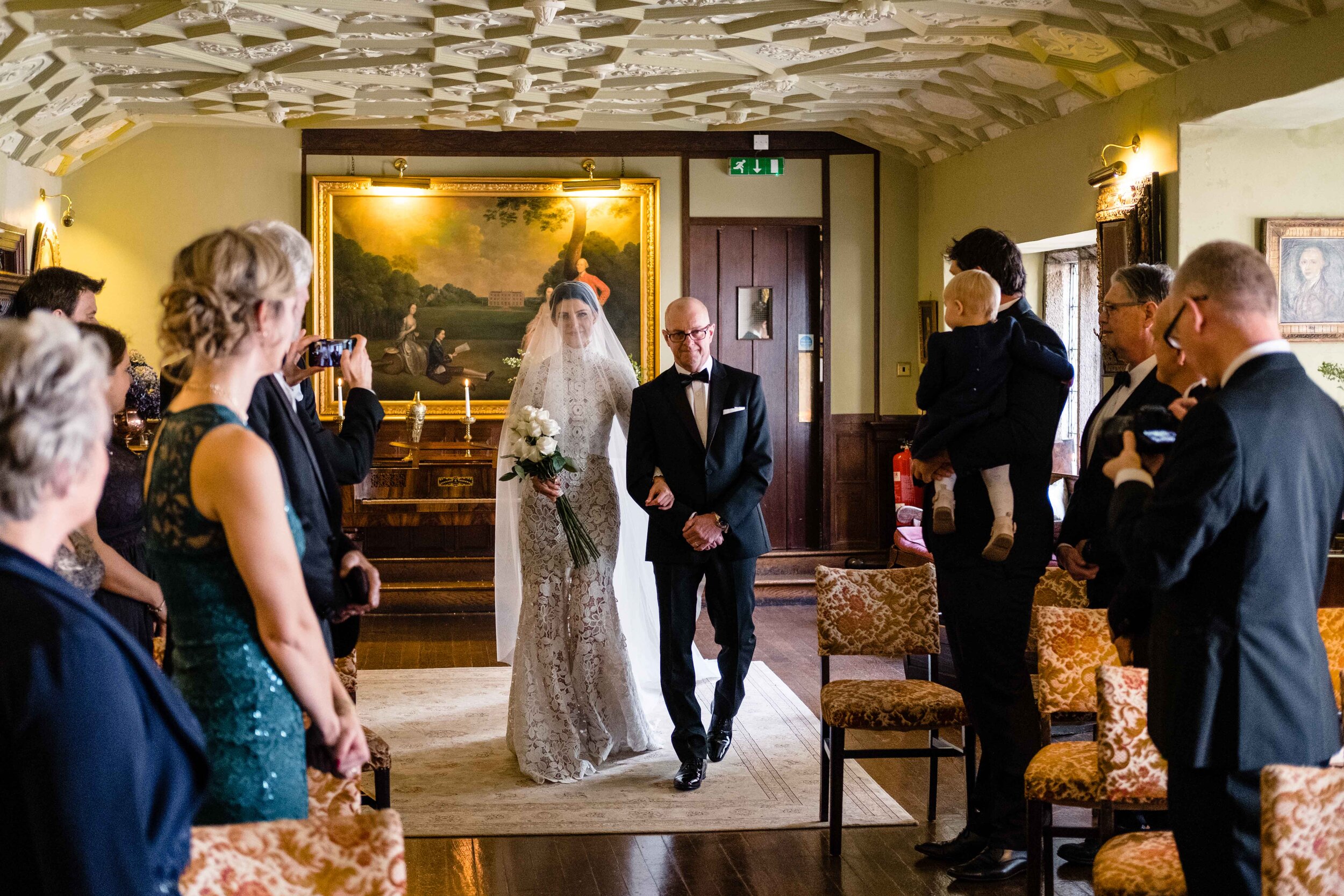 bride and father walking down aisle at Lewtrenchard