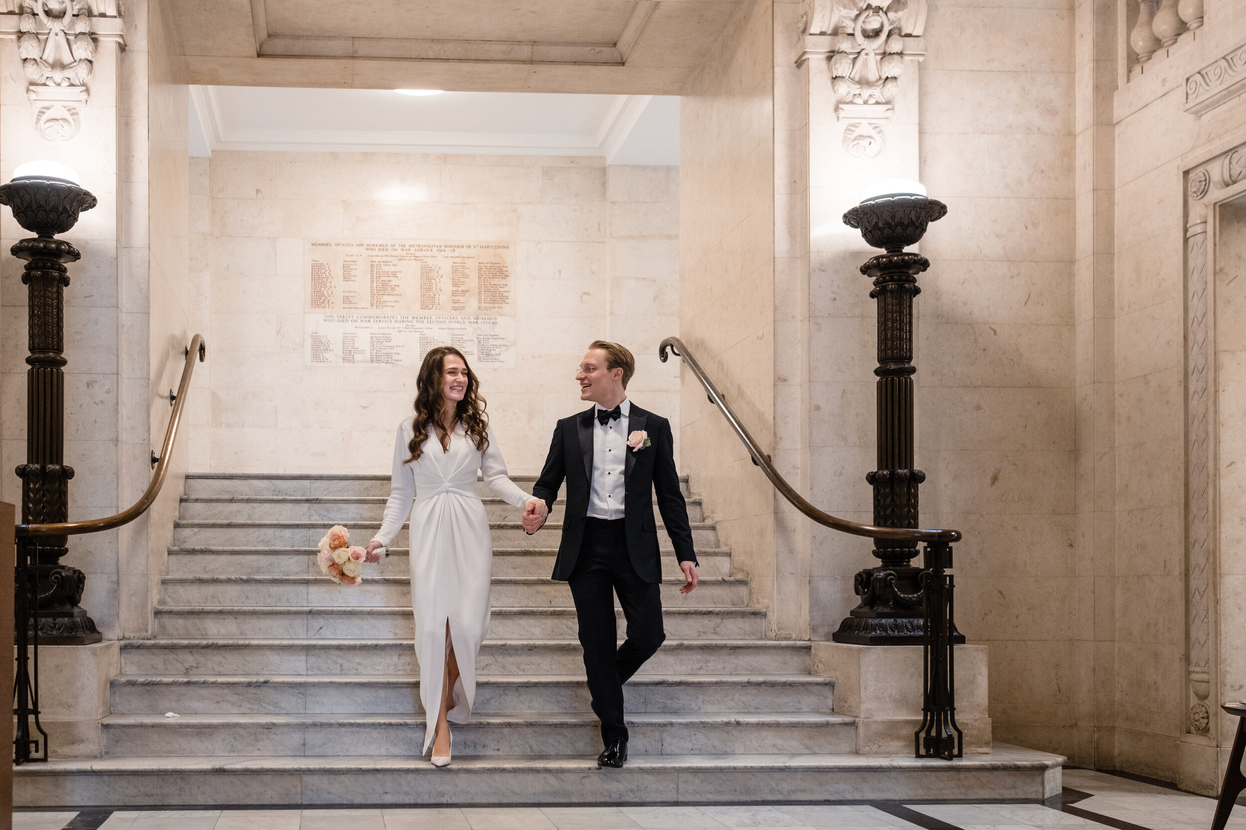 bride and groom coming down grand staircase in Old Marylebone town hall