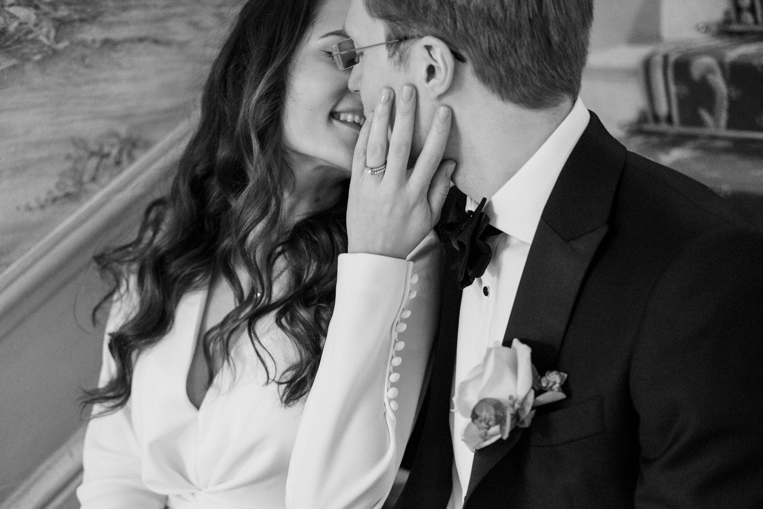 close up black and white of couple kissing showing wedding ring