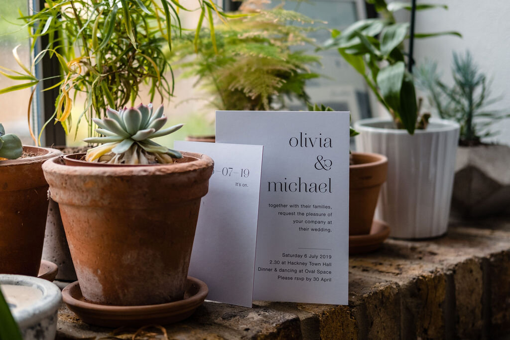 wedding invites and pots of succulents