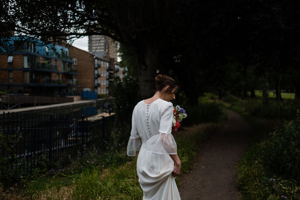 back top view of bride walking into woods