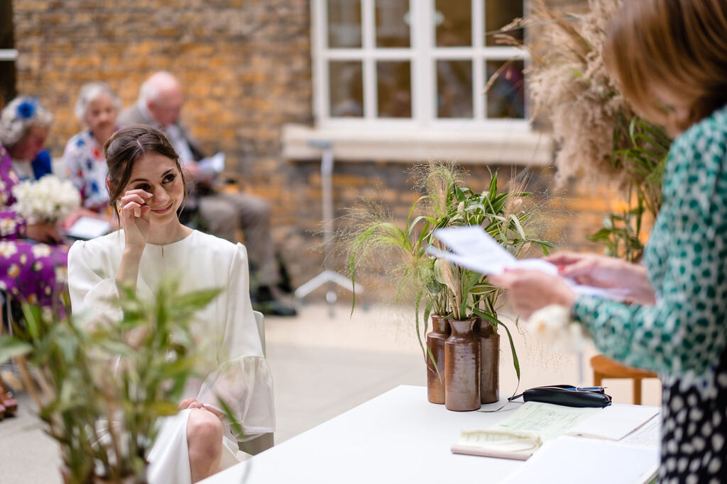 bride wiping away tear whilst listening to a speech