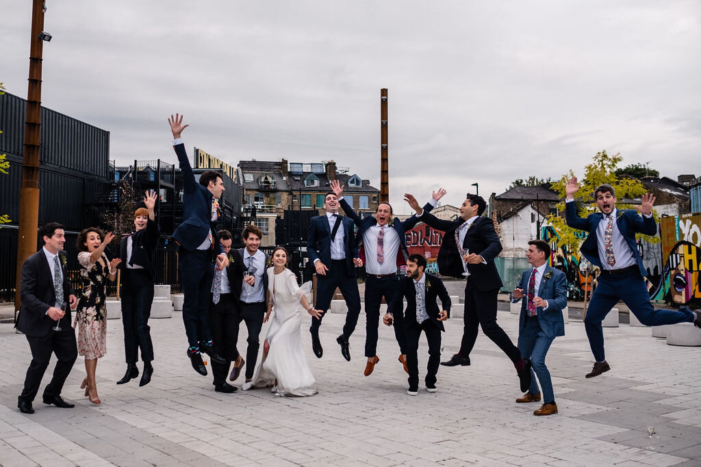 wedding party leaping in the air in hackney