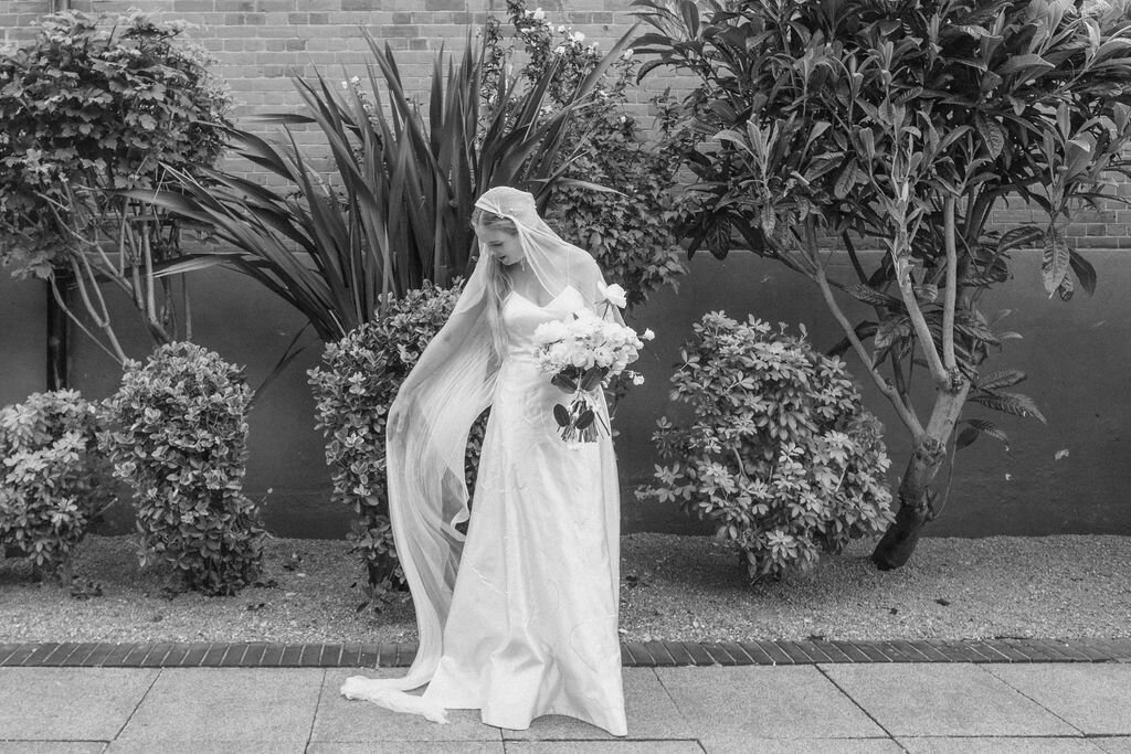black and white picture of bride in front of foliage