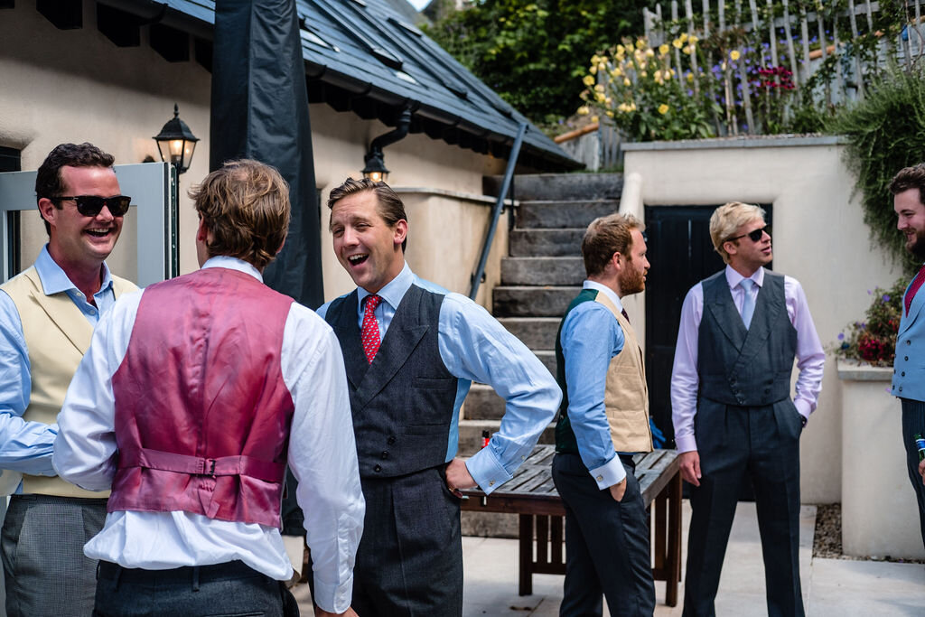 groomsmen drinking in courtyard before wedding