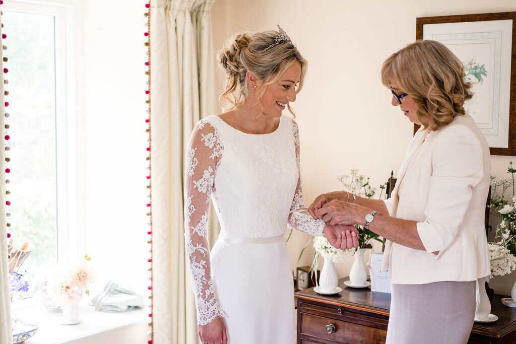 mother and bride she is helping her do up her cuffs