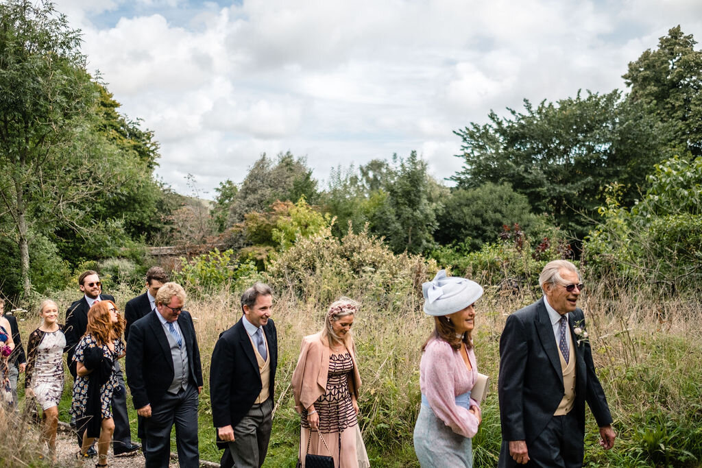 wedding guests walking up green path