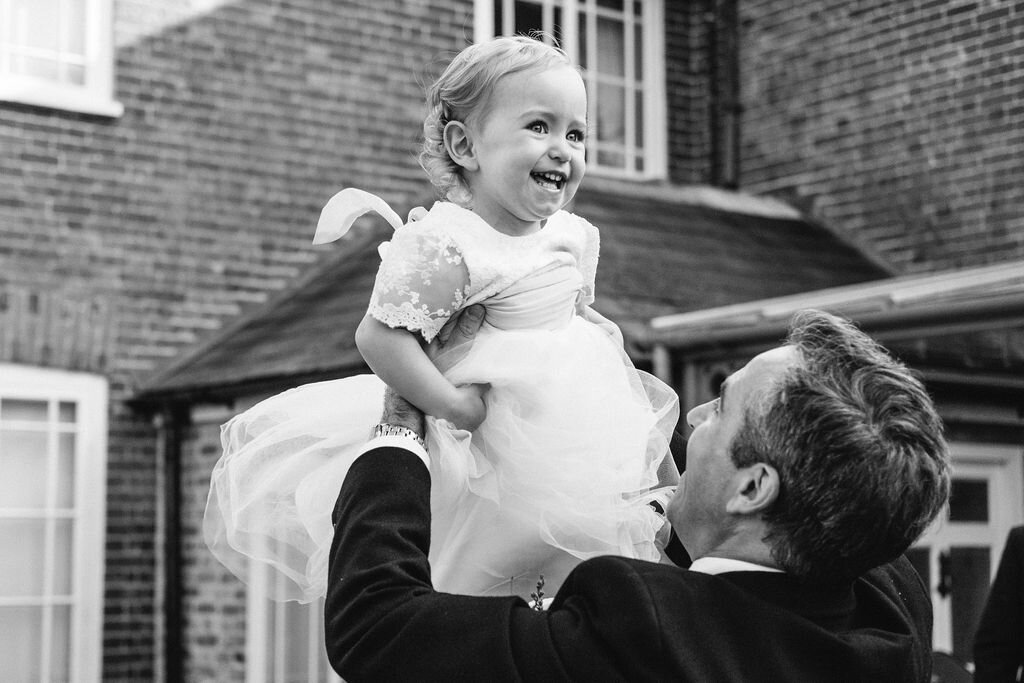 black and white of man throwing baby girl in the air