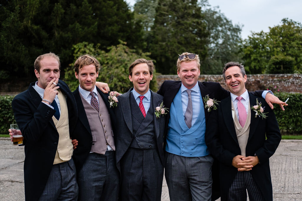6 men dressed smartly at a wedding