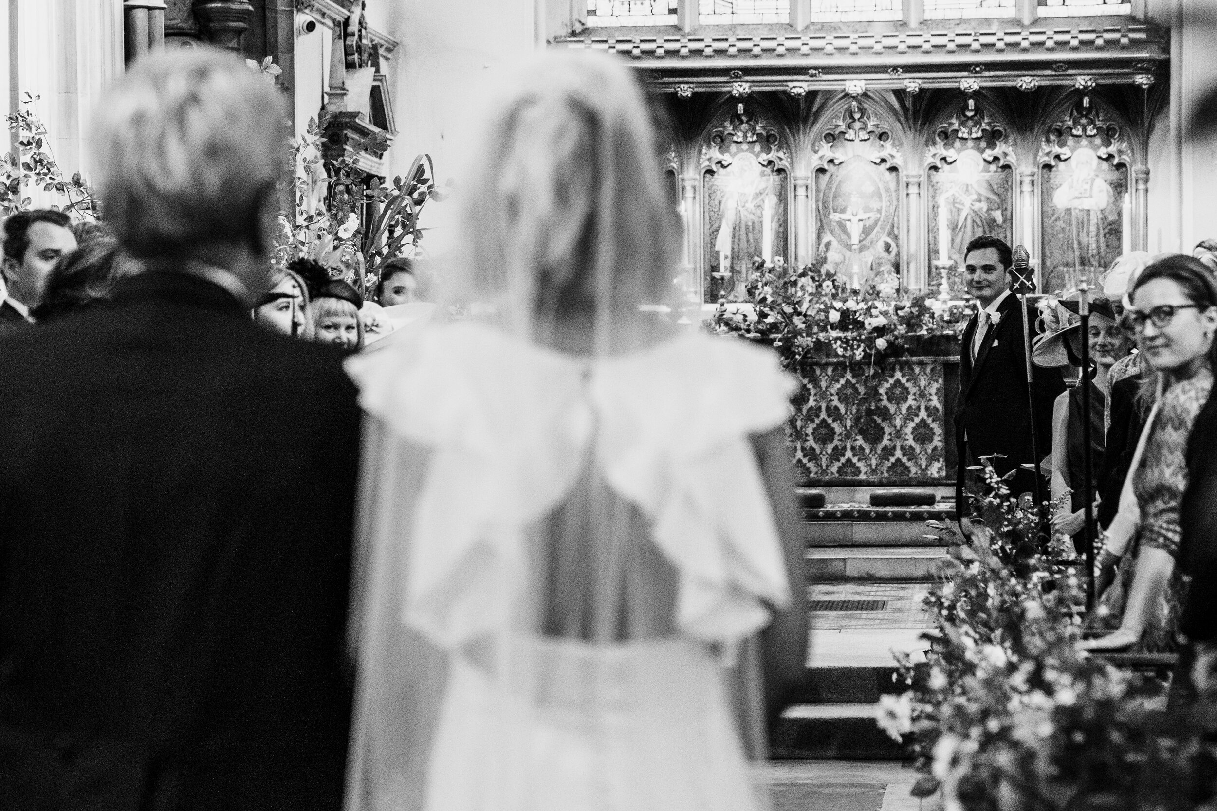 groom seeing bride for first time walking up  aisle with father