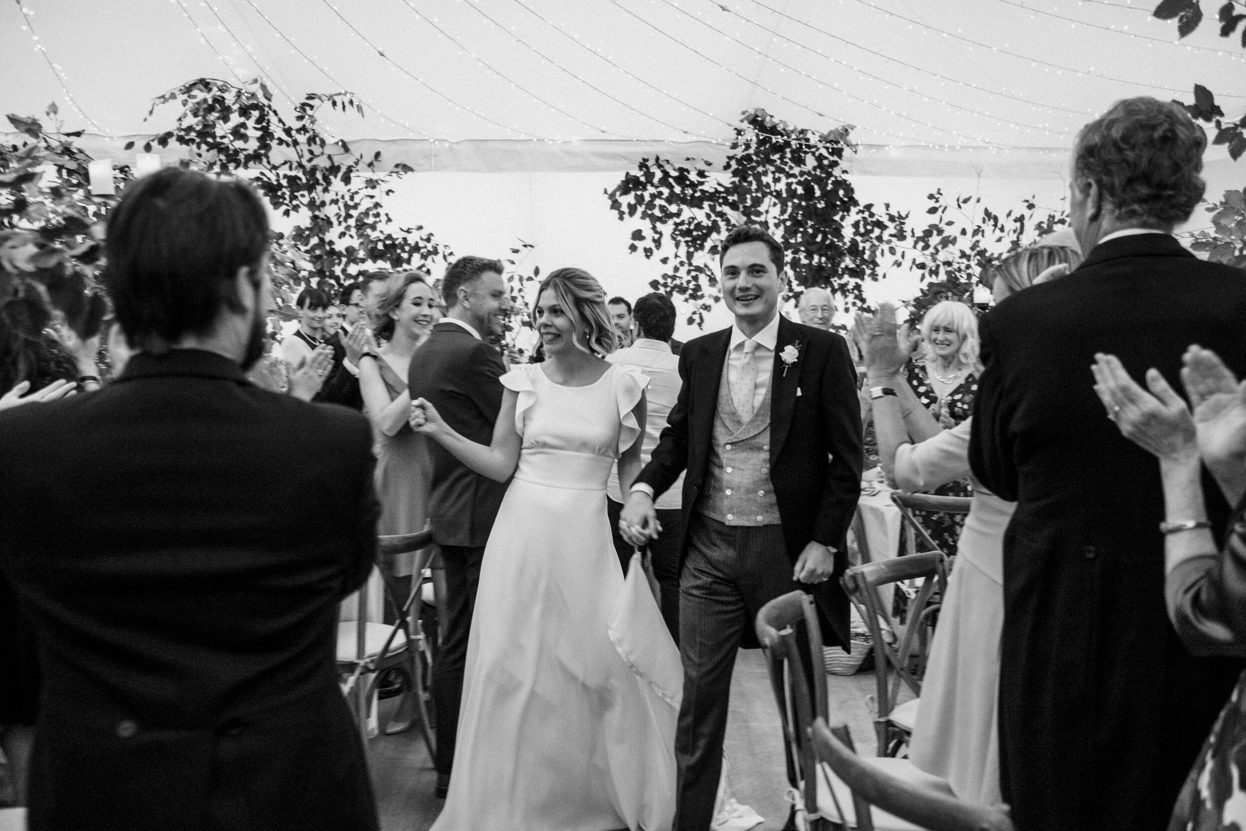 photo of bride and groom entering wedding reception