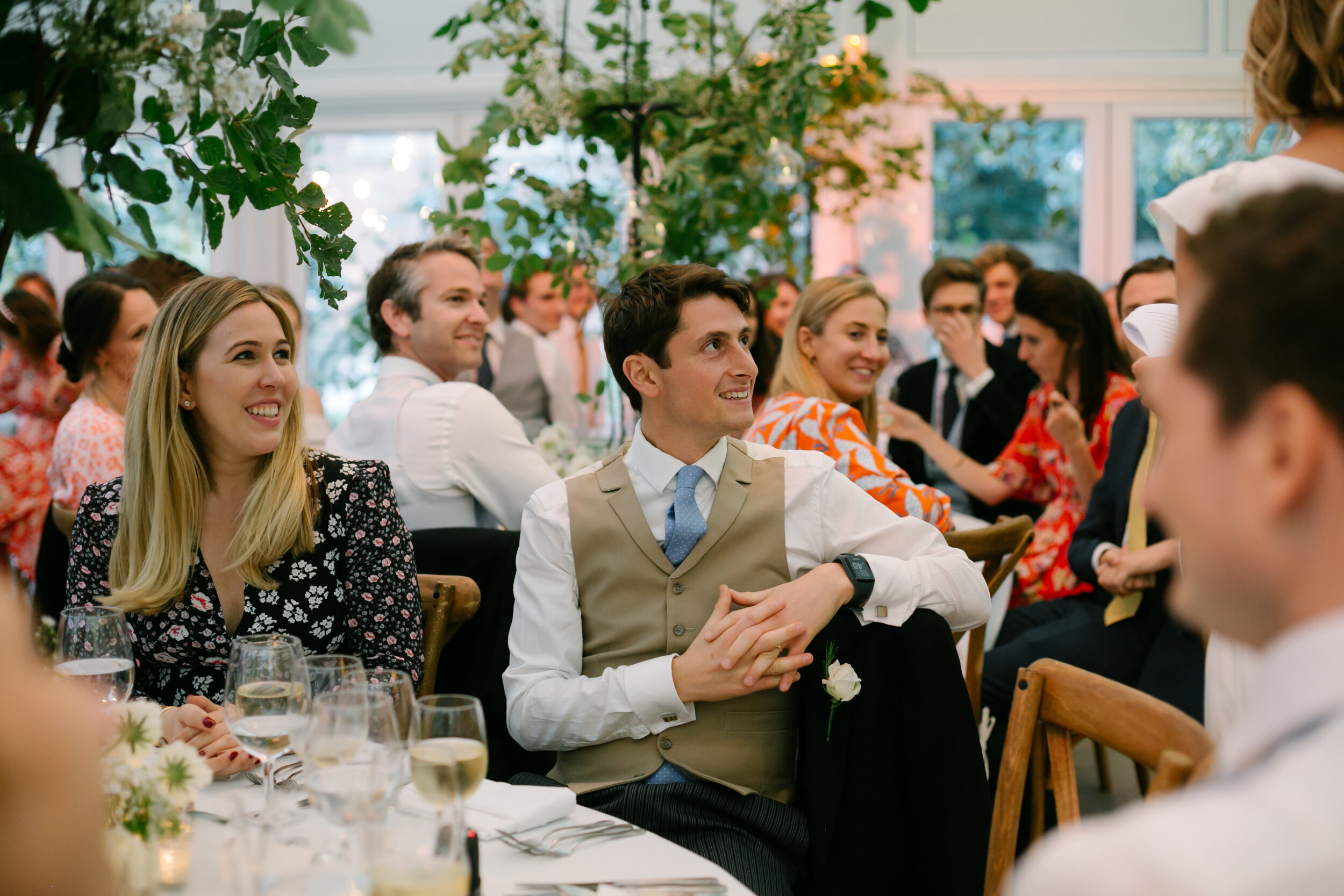 wedding guests at dinner listening to speeches