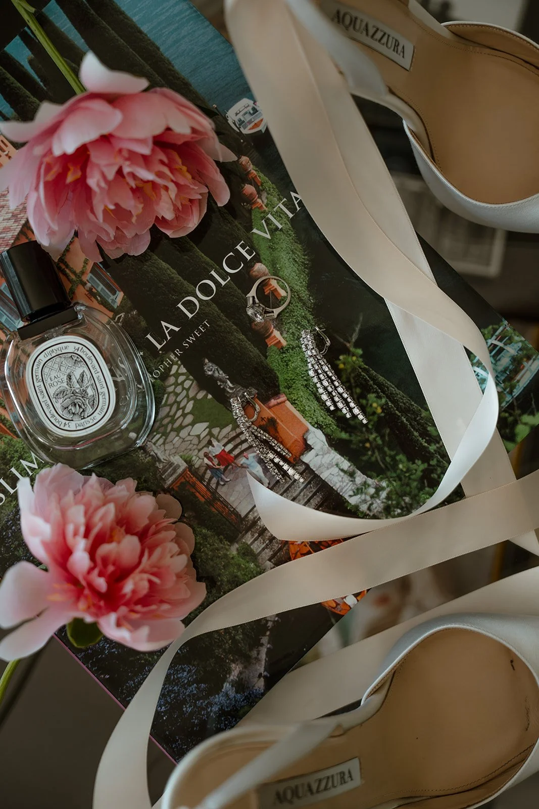 Wedding stationery styled with flowers and ribbon on a table.