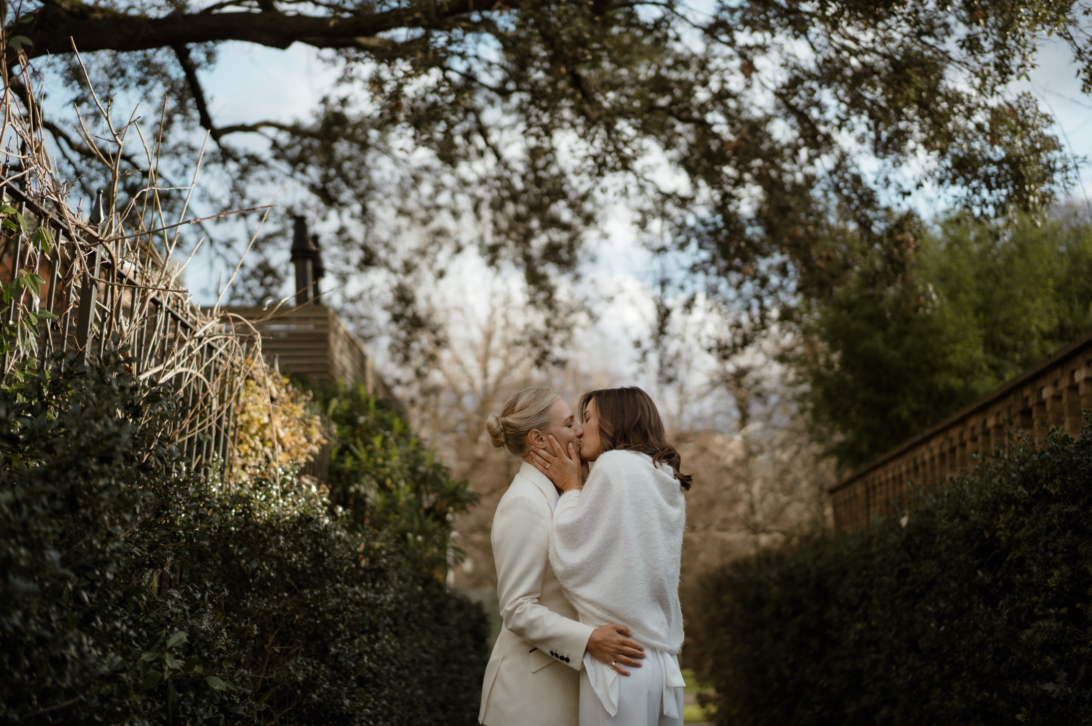 Couple kissing on a garden path during relaxed natural wedding portraits